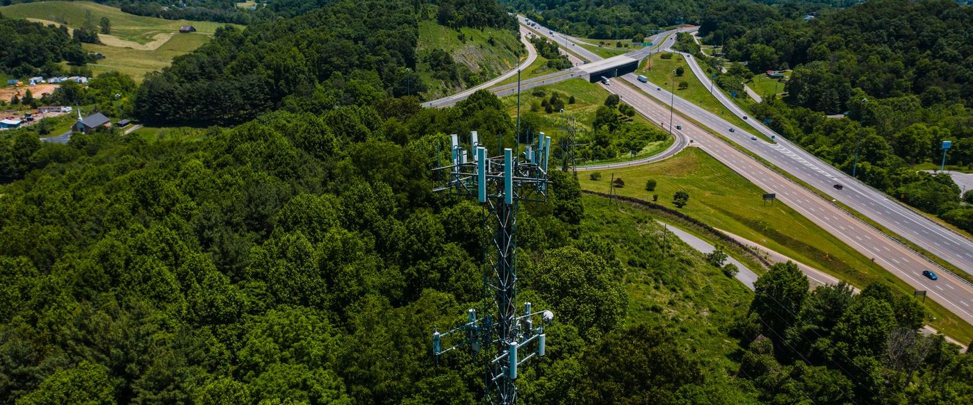 An interstate interchange cutting through wooded Appalachian ridges, seen from the air.