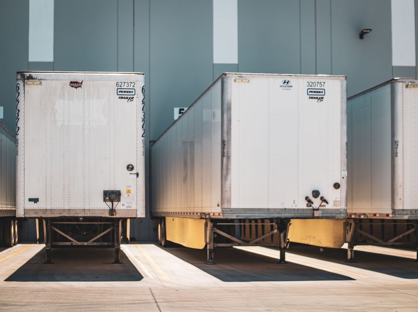 Dry van trailers backed into loading dock doors.